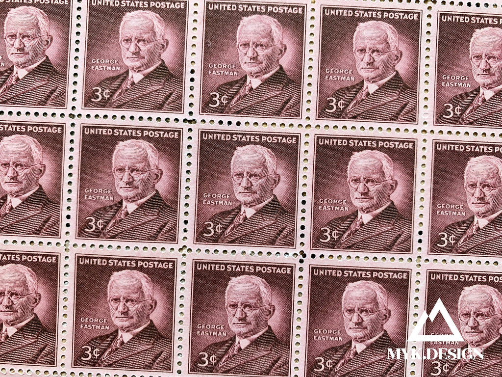 Close-up photo of the 1954 George Eastman 3¢ U.S. postage stamp, Scott 1062, featuring a portrait of the Kodak founder in a maroon design.