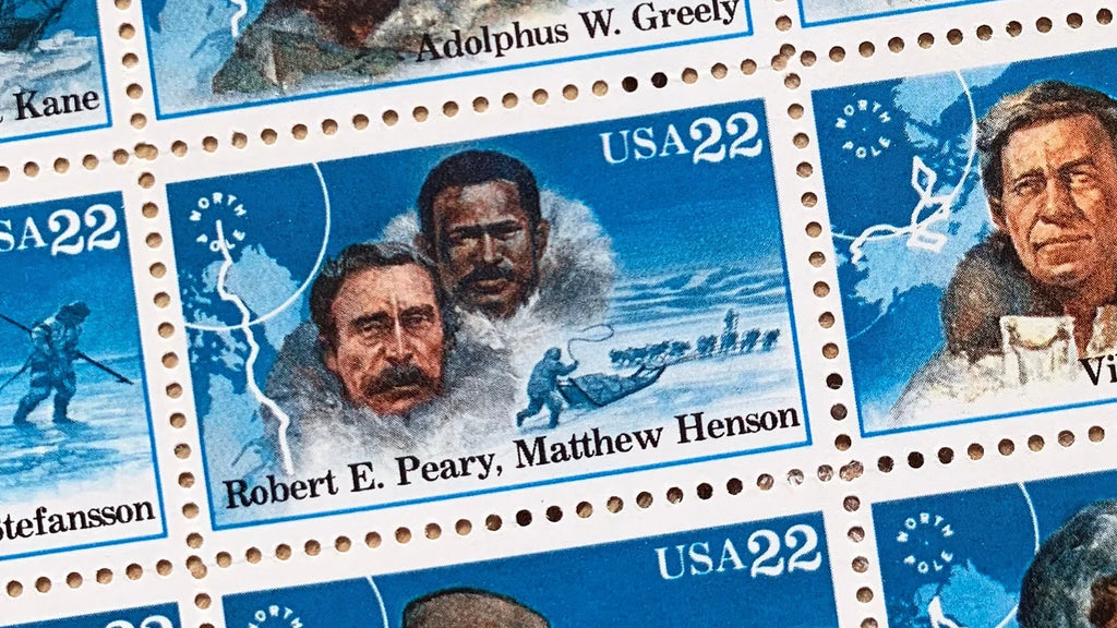 Close-up of the 1986 Arctic Explorers U.S. postage stamps (Scott 2220–2223), 22 cents each, featuring portraits of Matthew Henson, Robert Peary, Adolphus Greely, and Vilhjalmur Stefansson against icy Arctic landscapes.
